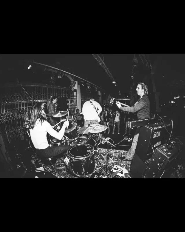 Le groupe sur scène vu de loin, photo noir et blanc